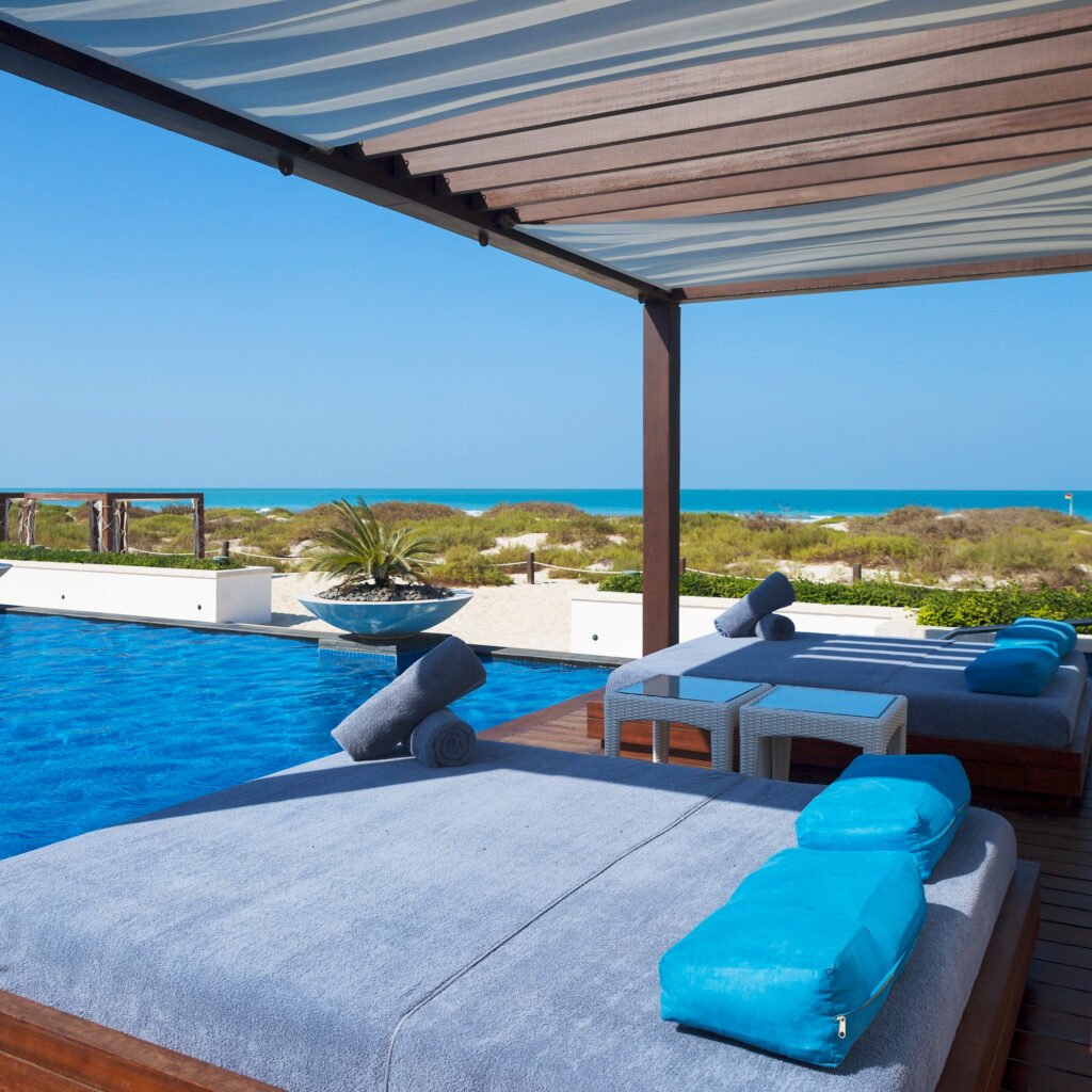 Pergola bioclimatique en aluminium au bord d'une piscine