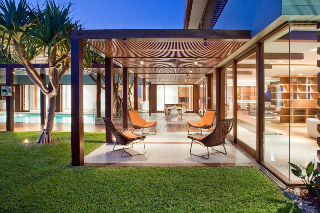 Salon de jardin sous une grande pergola bioclimatique en bois
